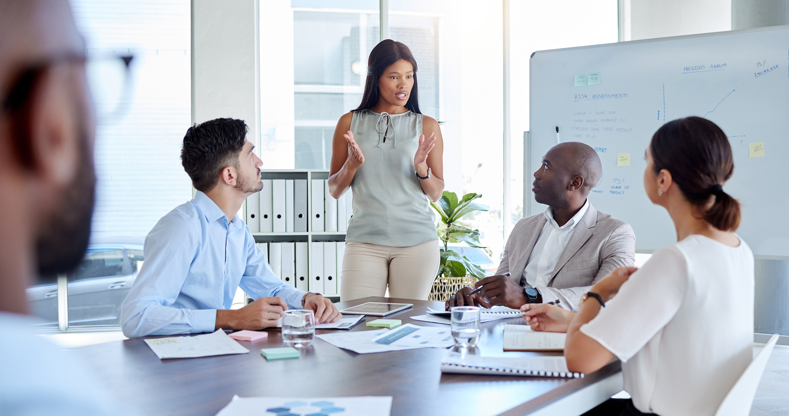 Team member presenting around a conference table, leaving a PEO for managed HR services